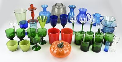 de nombreux vases et verres en verre de différentes couleurs sur la table