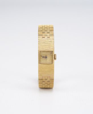 un gros plan d'une montre sur une surface blanche avec un fond blanc
