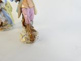 two figurines of a man and a woman on a white surface
