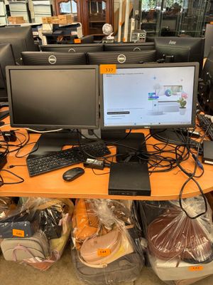 a desk with two monitors and a keyboard on it