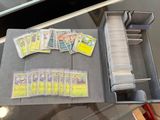 quelques cartes de baseball sont posées dans une boîte en métal sur une table