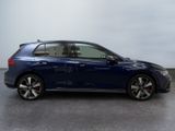 a blue volkswagen golf r - line is parked in a garage