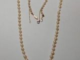 un gros plan d'un collier et d'une paire de boucles d'oreilles posés sur une table