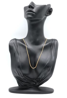 a black mannequin head with a gold chain on it