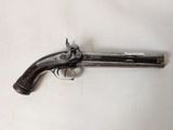 an old gun that is sitting on a white surface
