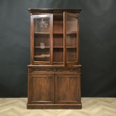 an antique oak bookcase with glass doors
