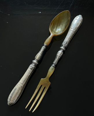 two spoons and a fork sitting on a table