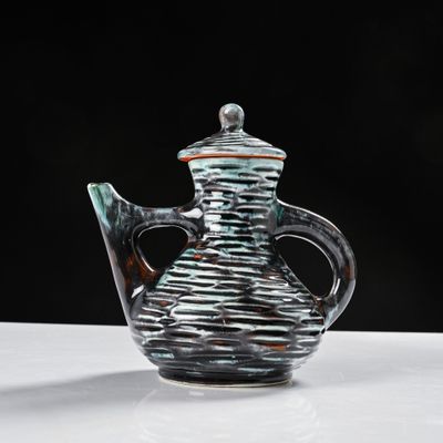 a glass teapot sitting on a table with a black background