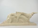 statue représentant une femme et un chien sur un rocher, avec le ciel en arrière-plan