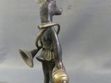 bronze statue of a deer with a bell and a bird on its back