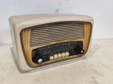 une vieille radio posée sur une table près d'un mur blanc