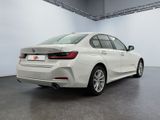 the rear of a white bmw 3 series sedan parked in a garage