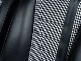 the back of a black and white checkered jacket with a black tie
