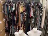 two mannequins standing in front of a rack of clothes