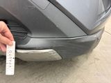 a hand that is holding a piece of paper near the front of a car
