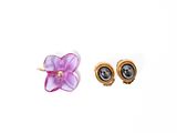 two pairs of earrings with purple flowers on them on a white surface