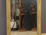 a large mirror with a statue of a man and a woman in it