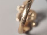 a close up of a gold ring on a white surface
