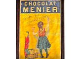 Une vieille enseigne « Menner » représentant un bonhomme en chocolat est accrochée au mur.