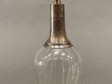 a glass bottle with a metal stopper sitting on a table