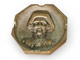 une image représentant une assiette en or sur laquelle figure le portrait d'un homme