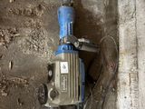 une perceuse accrochée au mur à côté d'un morceau de béton
