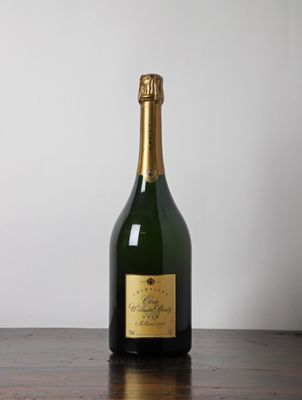 une bouteille de champagne posée sur une table en bois
