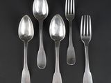 six silver spoons and a fork on a black surface