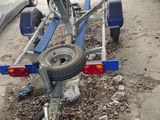 un petit bateau sur une remorque, garé sur un parking