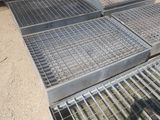 plusieurs grilles métalliques sont empilées les unes sur les autres à même le sol