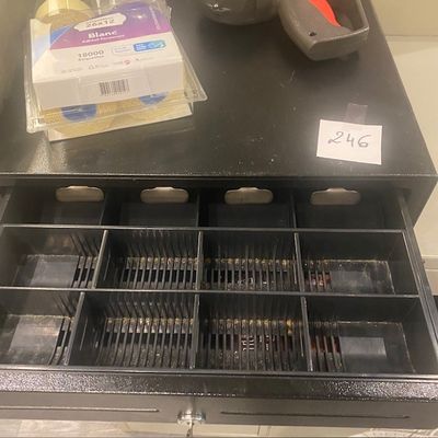une image représentant une caisse enregistreuse contenant beaucoup d'argent liquide