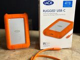 an orange hard drive sitting on top of a wooden table next to a box