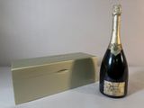 une bouteille de champagne à côté d'un coffret sur une table
