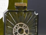 a bottle of perfume sitting next to a bottle of wine