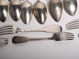 a lot of silver spoons and forks on the table