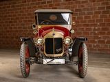 a red and gold car parked in front of a brick wall