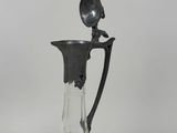 a glass pitcher with a spoon in it on a table