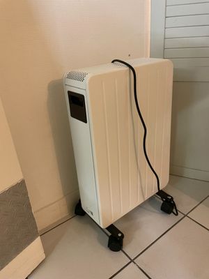 un radiateur blanc posé à même le sol, près d'un mur