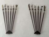 four metal swords on a white wall next to each other