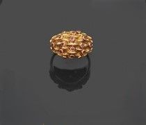 une bague en or posée sur une surface noire, avec un reflet sur cette surface