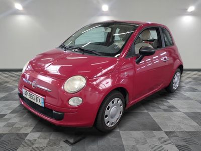petite voiture rouge garée sur un sol en dalles à damier dans un garage