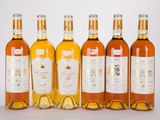 six bouteilles de vin sont alignées sur une surface blanche