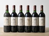 six bottles of wine are lined up on a wooden table