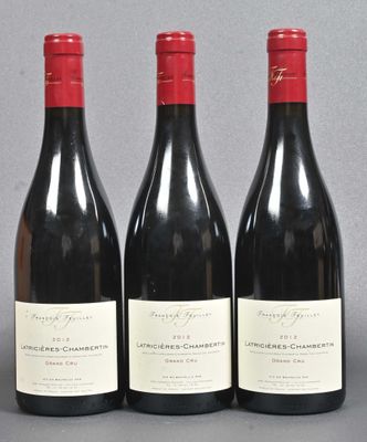 three bottles of red wine are lined up on a table