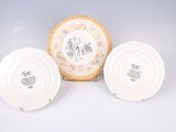 three white plates with designs on them sitting next to each other