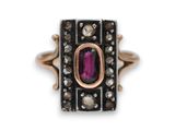 un gros plan d'une bague ornée d'une pierre rose entourée de diamants