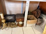 une étagère sur laquelle se trouvent une horloge, une boîte dorée, une autre horloge et d'autres objets