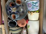 a cardboard box filled with vases and other items