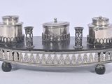 a silver plate with three silver containers on it
