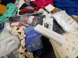 a pile of clothes and other items on a bed